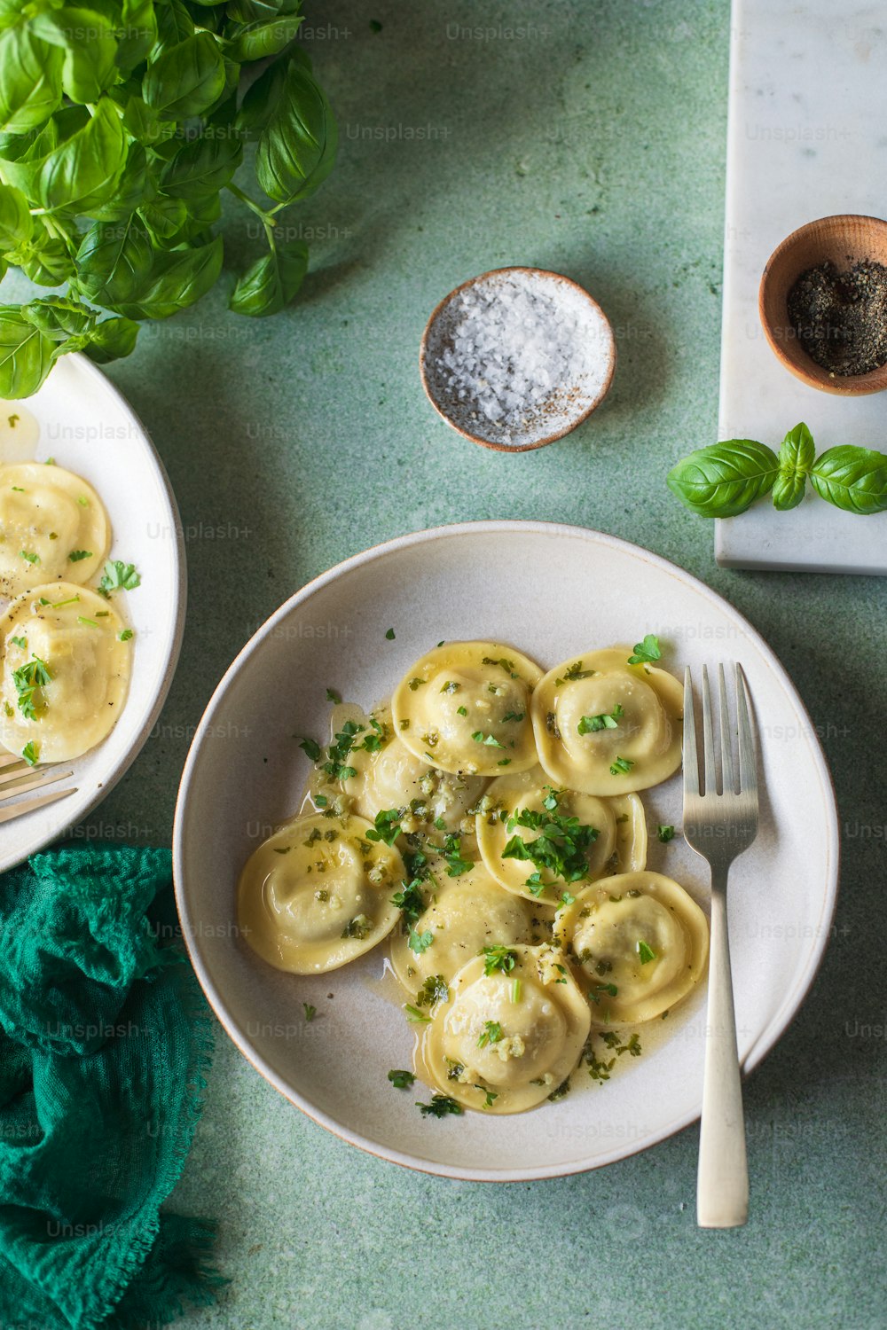 a plate of ravioli with parsley on the side