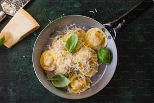 um prato de ravioli com queijo e manjericão