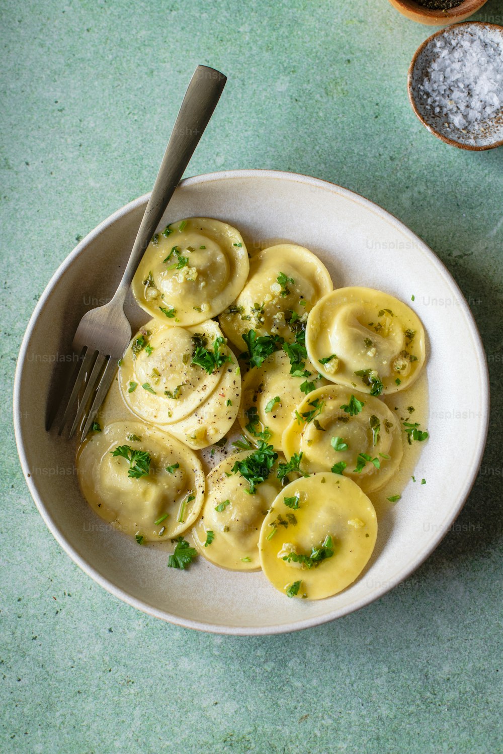 a bowl of ravioli with parsley on top