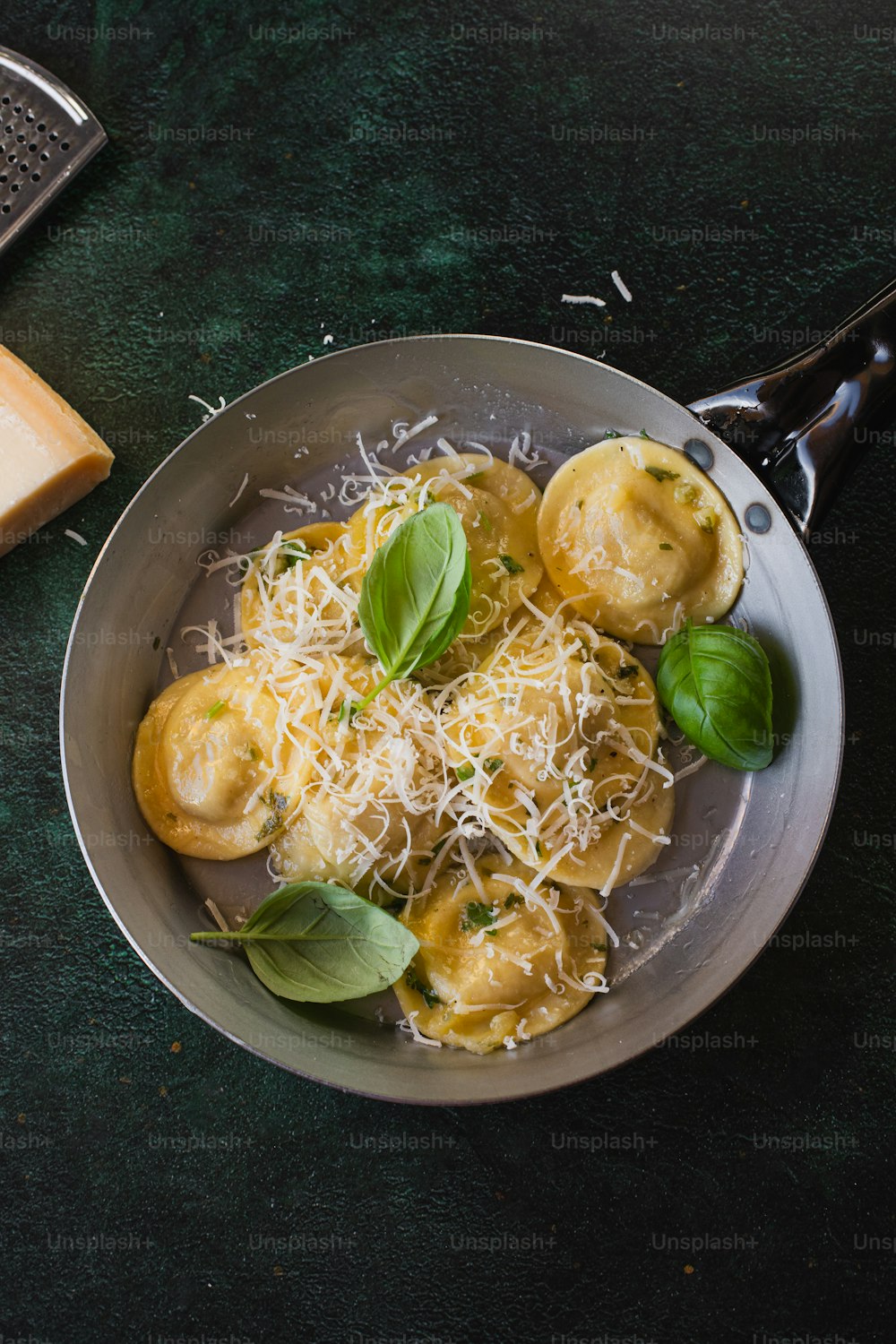 a plate of ravioli with basil and parmesan cheese