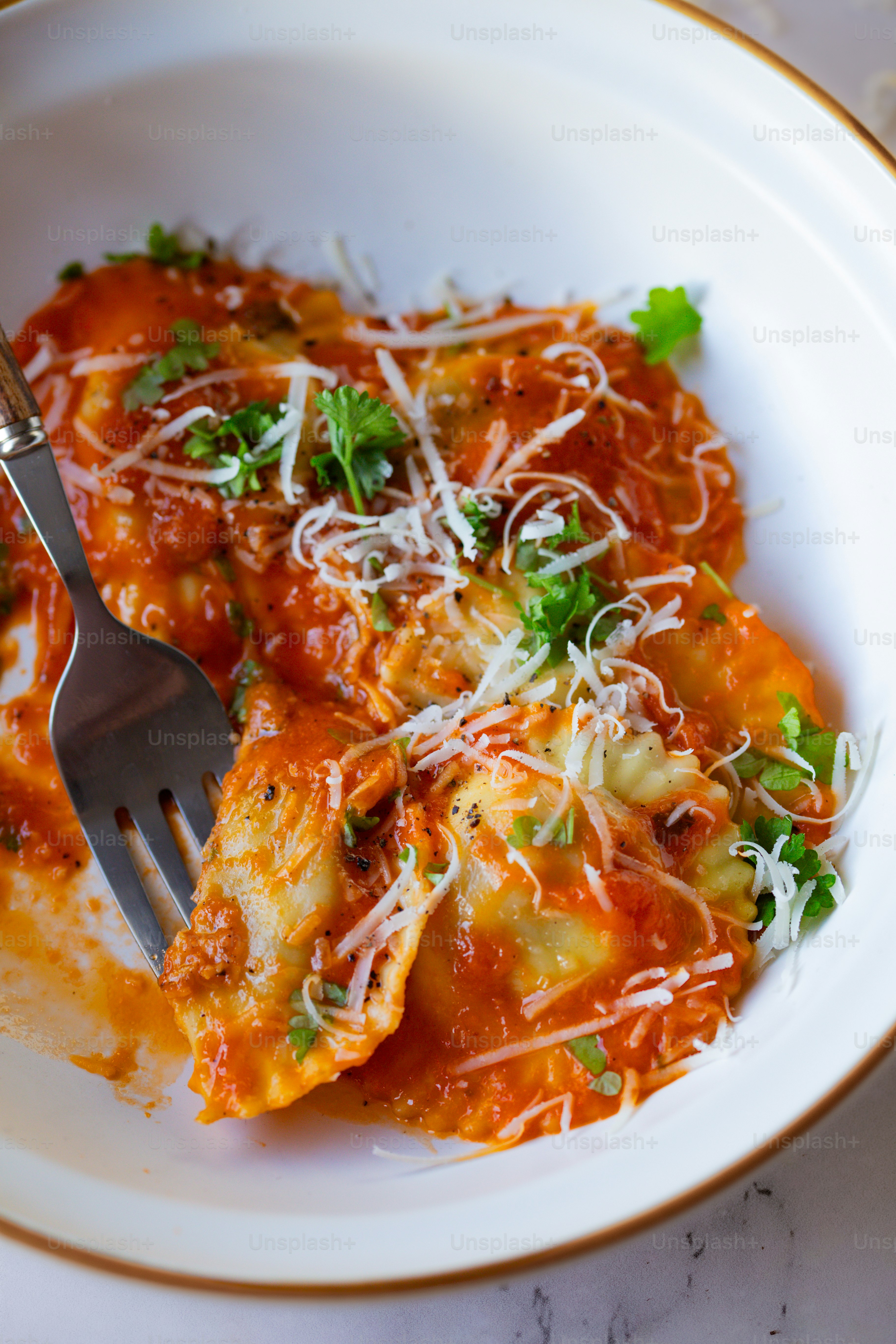 une assiette blanche garnie de lasagnes recouvertes de sauce et de parmesan