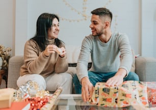 a man and woman sitting on a couch with presents