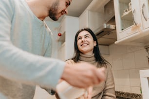 a man and a woman standing in a kitchen