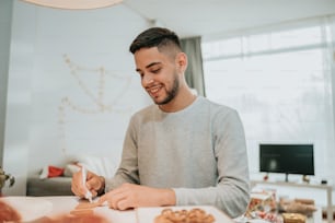 a man sitting at a table writing on a piece of paper