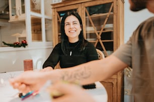 a woman sitting at a table in front of a man