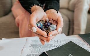 a woman holding a handful of marbles in her hands