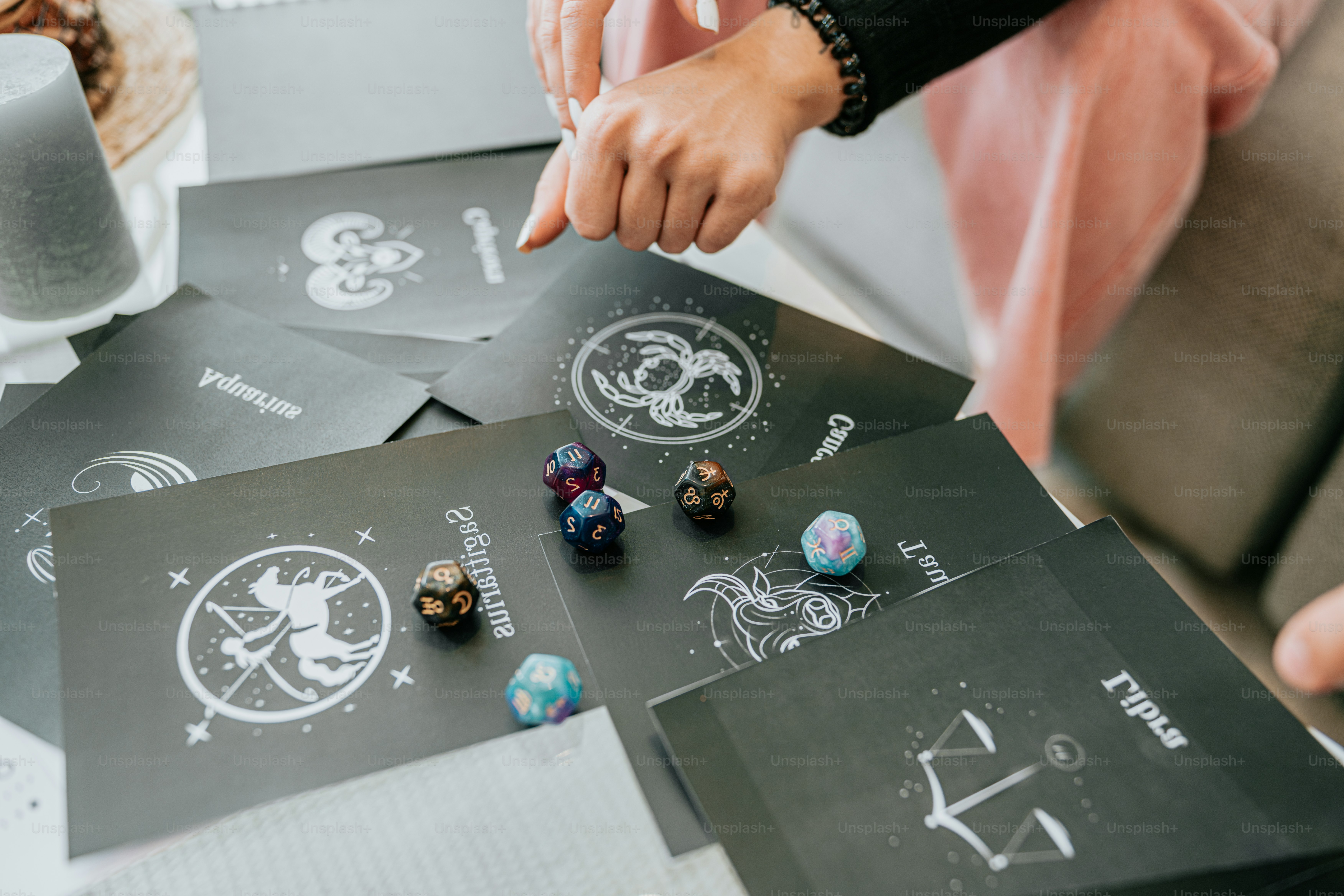 a person holding a dice on top of a table