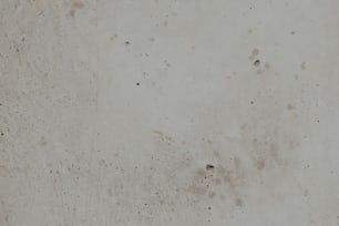 a close up of a cement wall with a clock on it