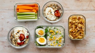 four containers of food are arranged on a table