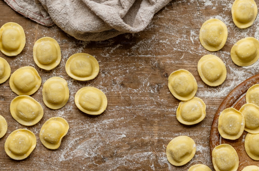 uma mesa de madeira coberta com muitos ravioli crus