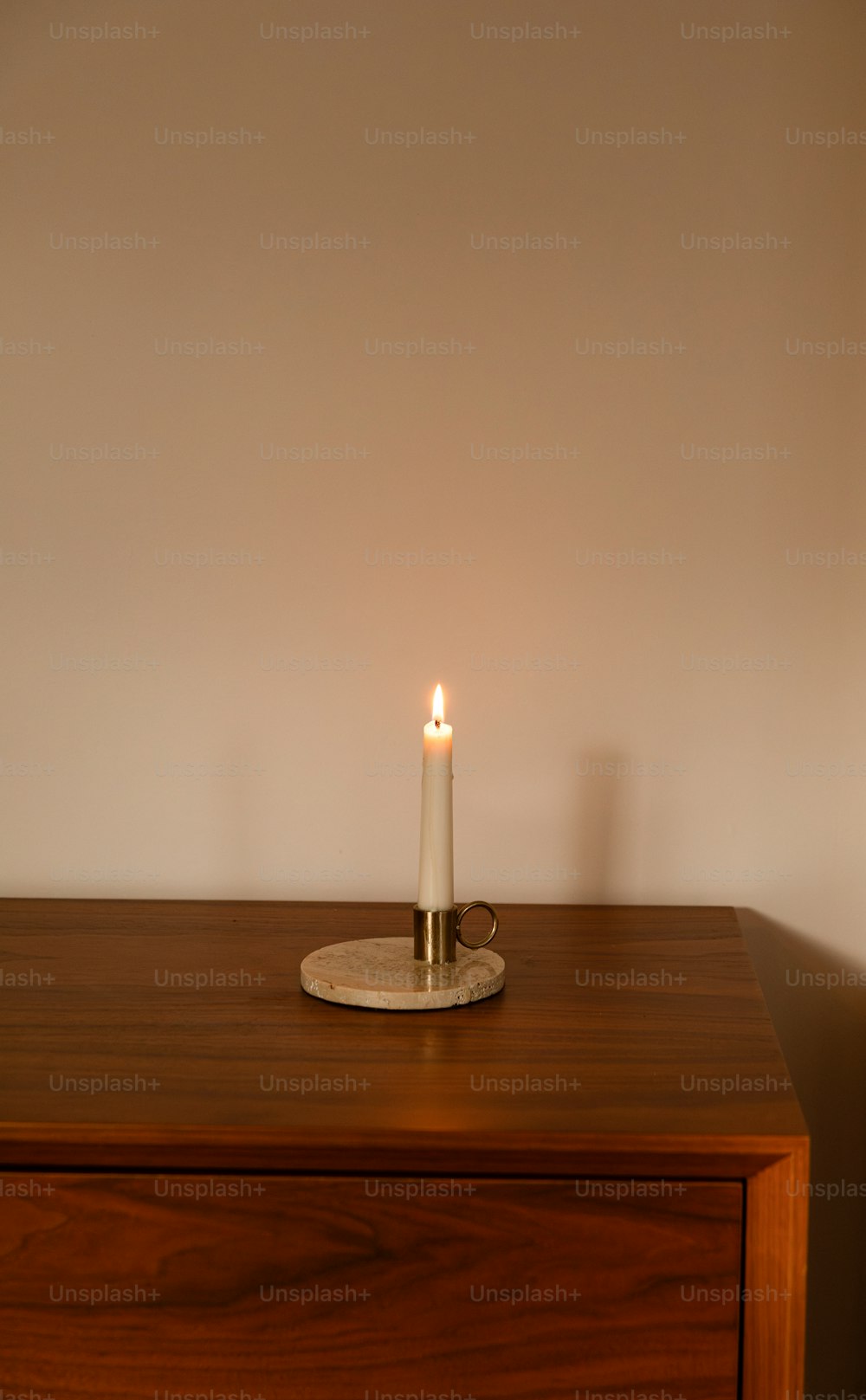 a lit candle sitting on top of a wooden table