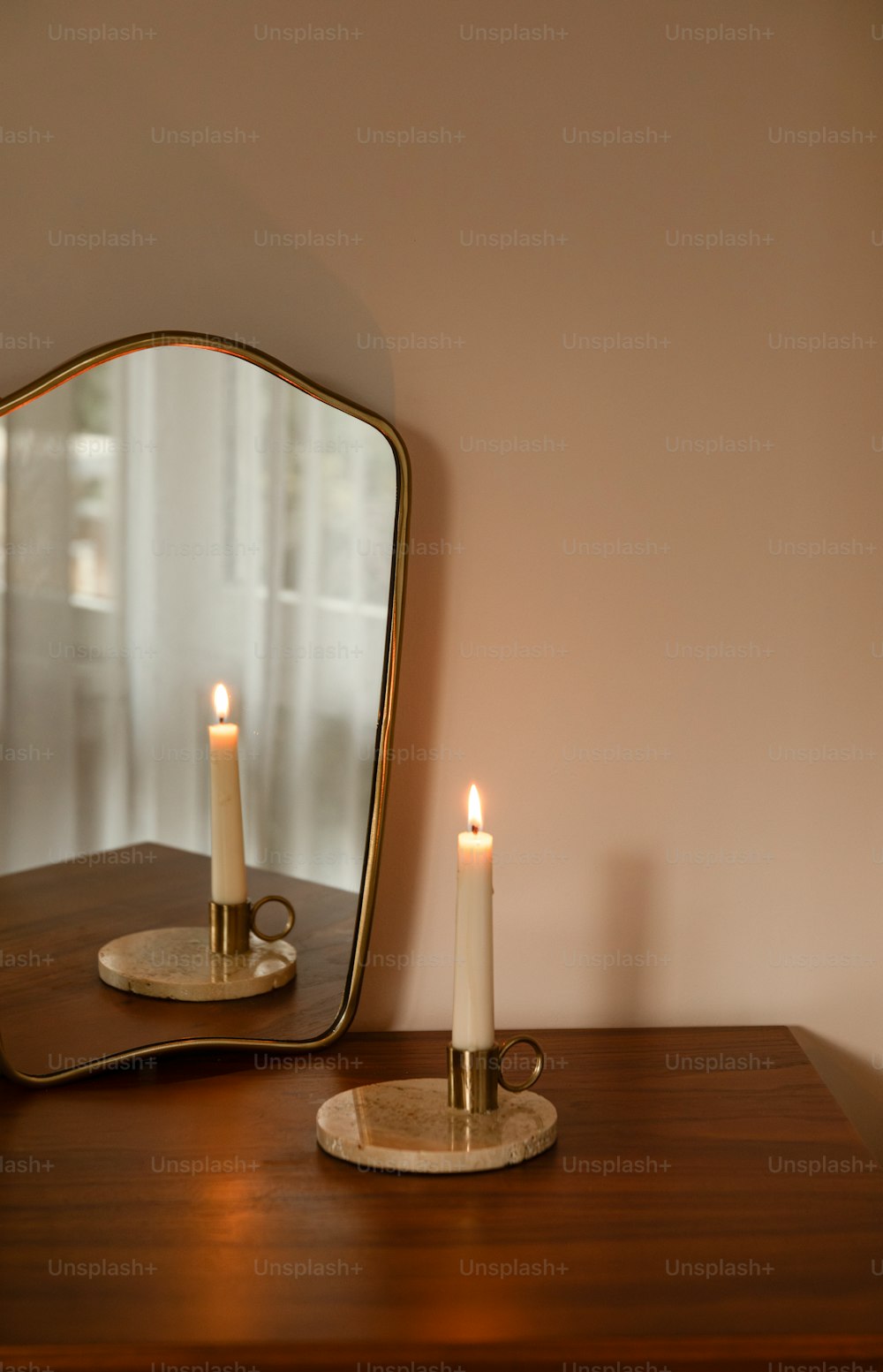 a candle sits on a table in front of a mirror