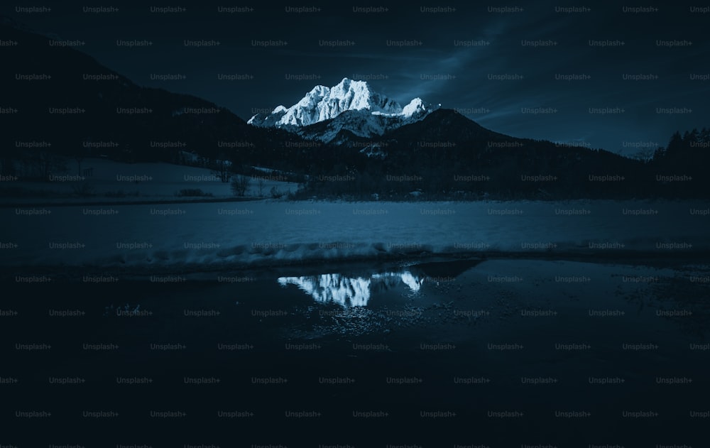 a mountain range is reflected in the still water of a lake