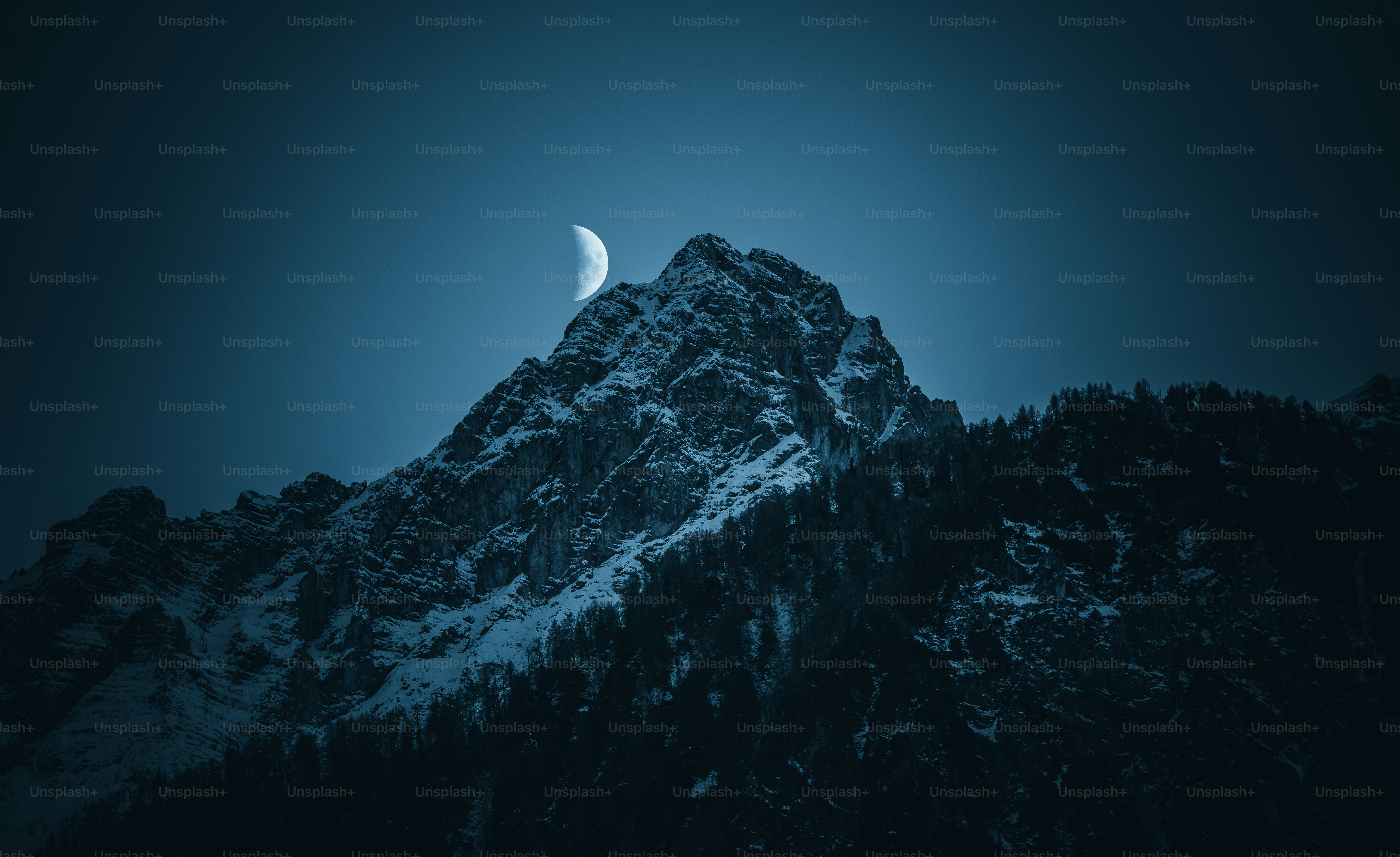 une montagne avec une demi-lune dans le ciel