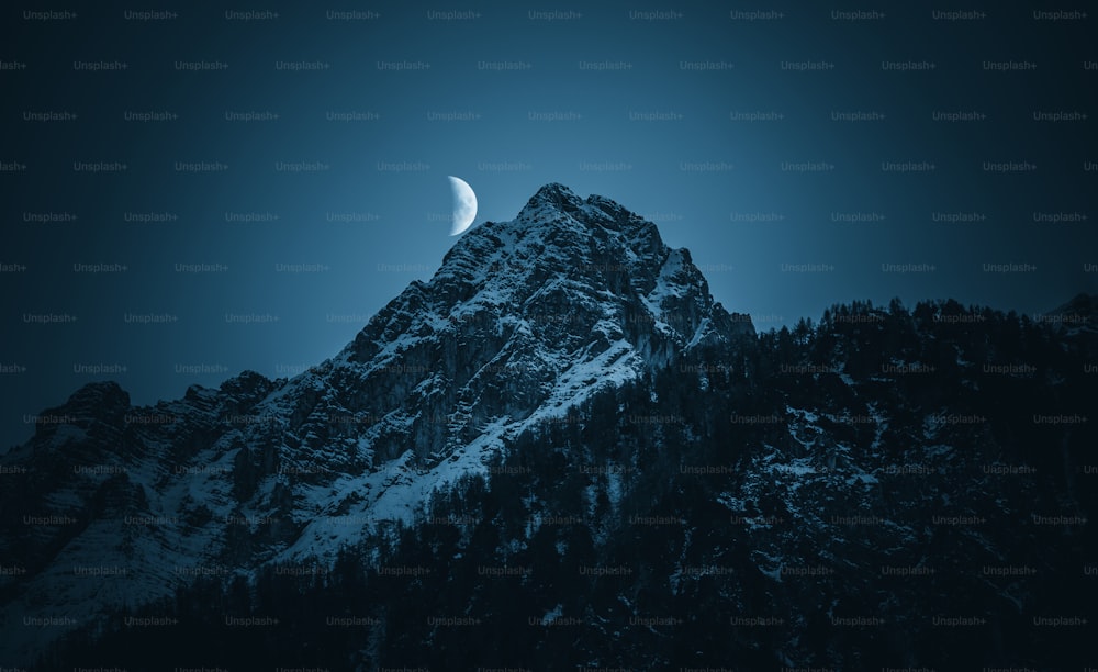 a mountain with a half moon in the sky