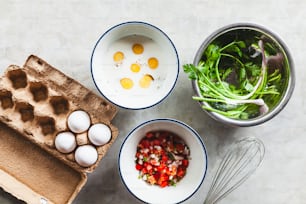 a table topped with bowls of food and eggs
