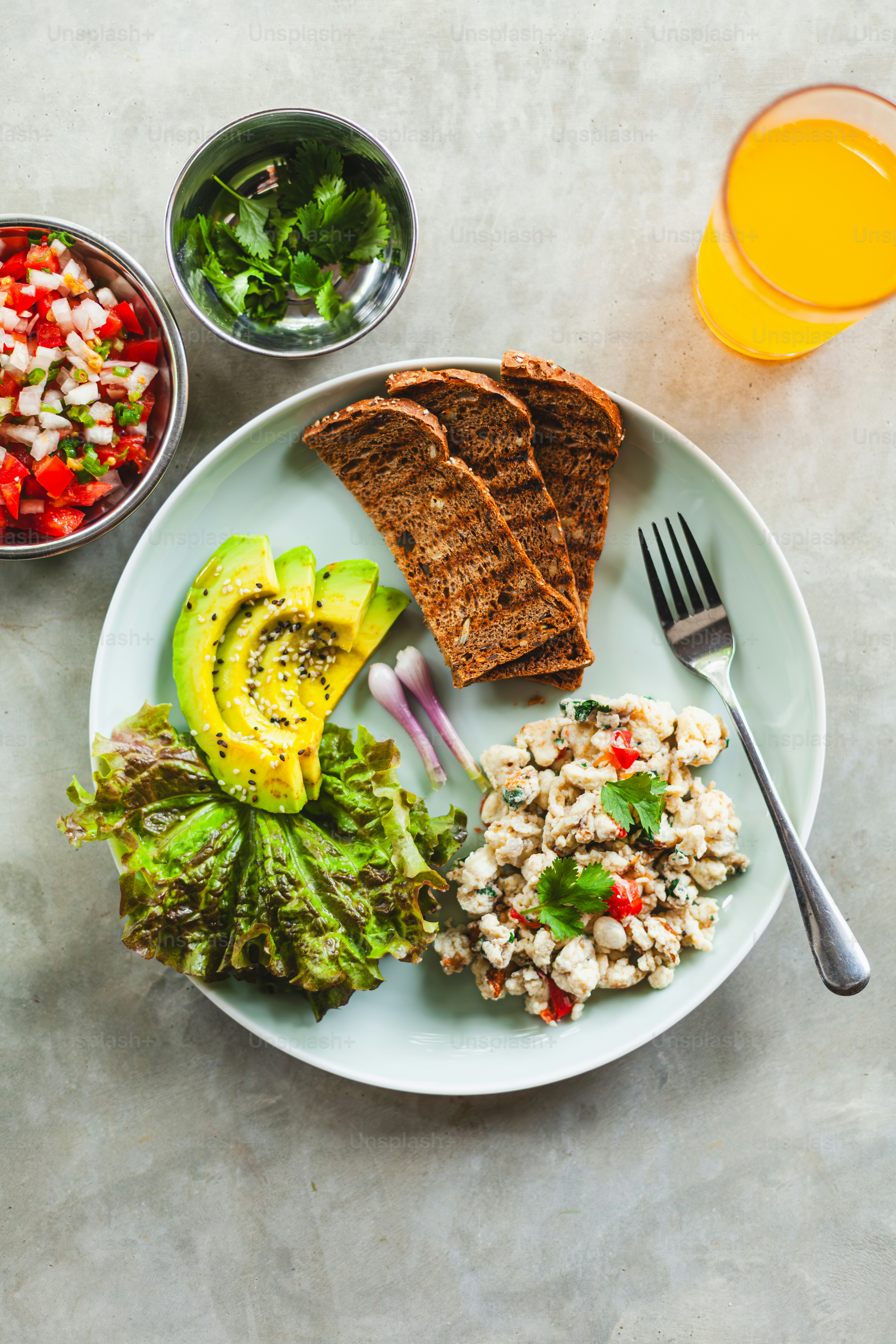 un piatto bianco condito con un'insalata e un panino