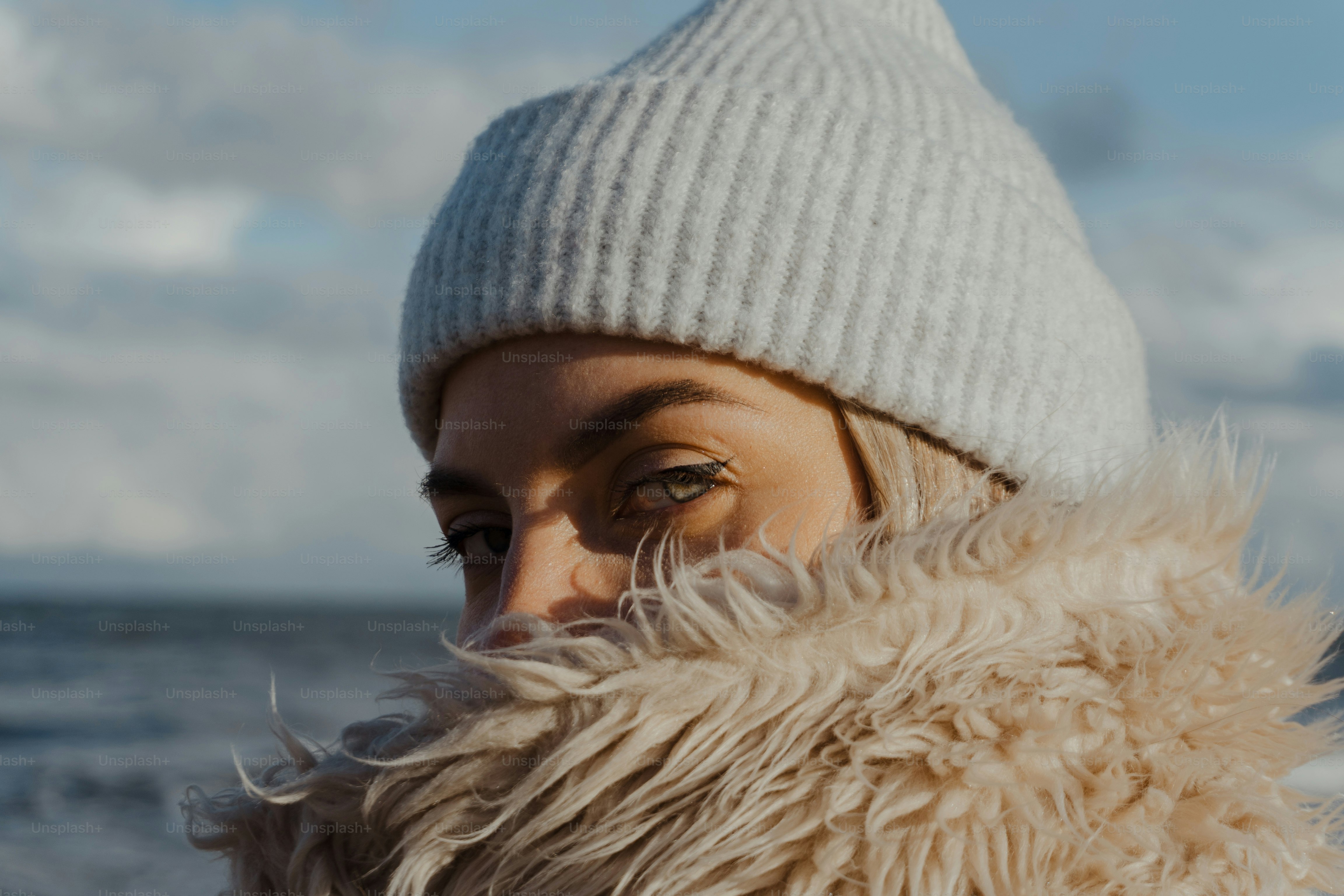 a woman wearing a white hat and a furry coat