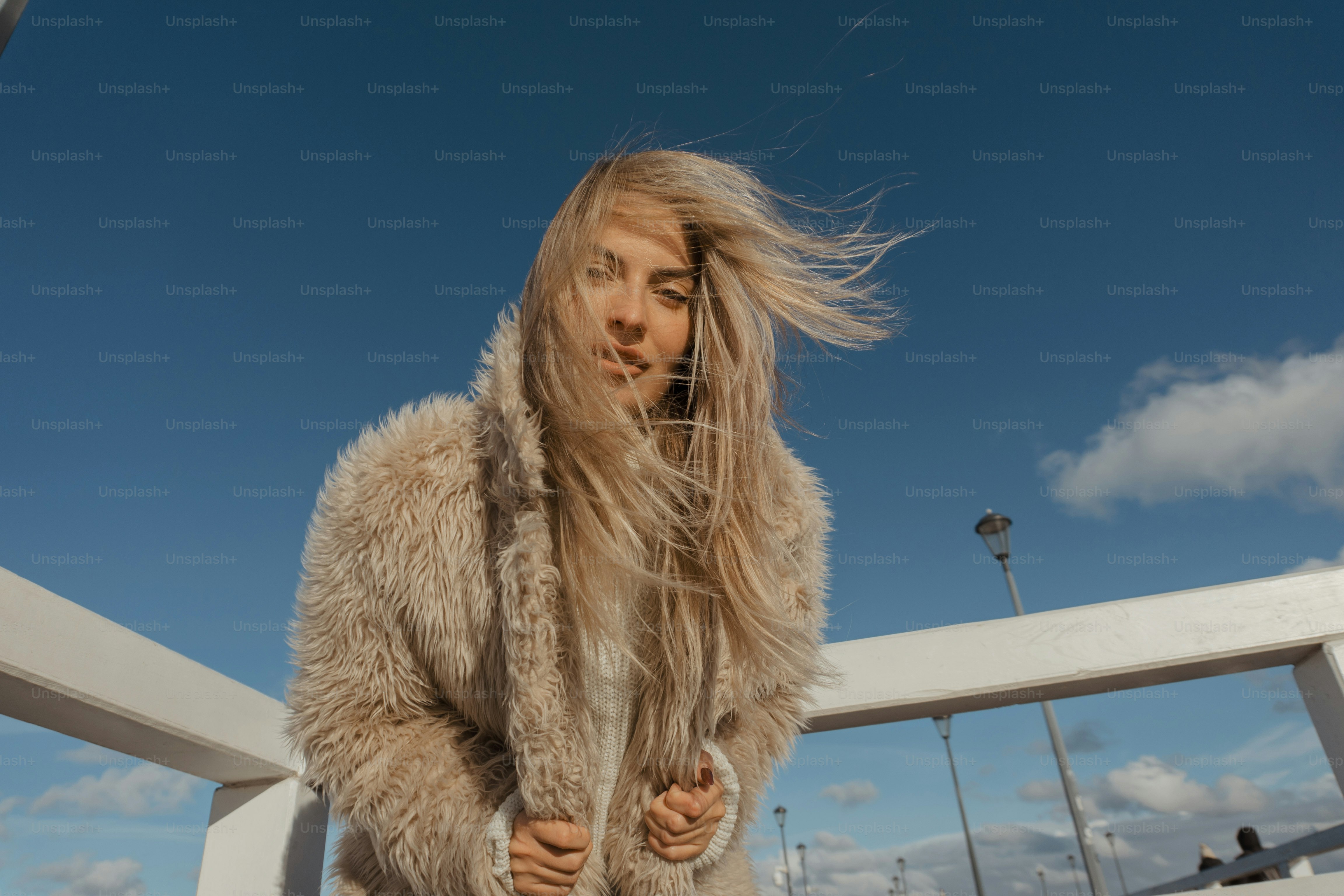 eine Frau mit langen Haaren steht auf einer Brücke