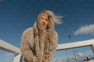 una donna con i capelli lunghi in piedi su un ponte