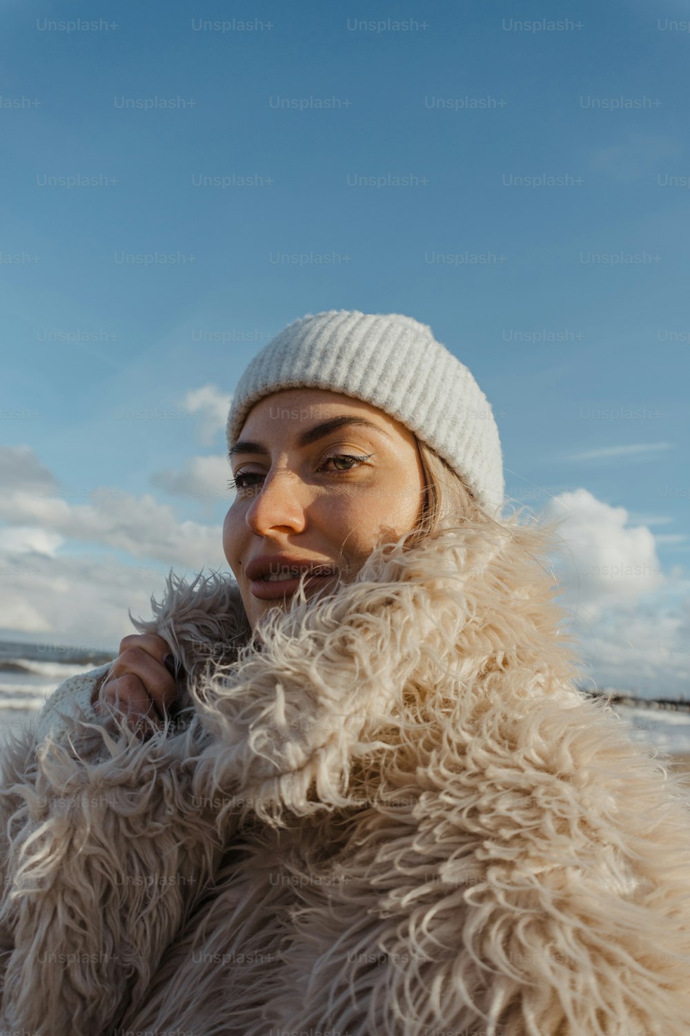 une femme coiffée d’un chapeau blanc et d’un manteau de fourrure