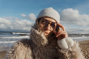 a woman in a fur coat on the beach