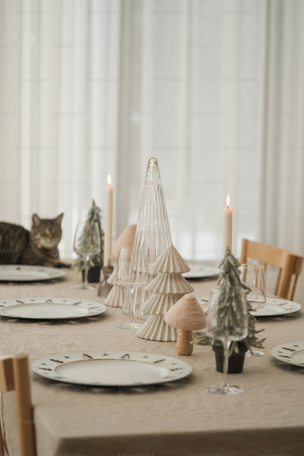 a table set for christmas with a cat sitting on the table