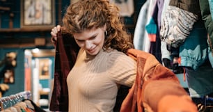 a woman looking through a jacket in a clothing store