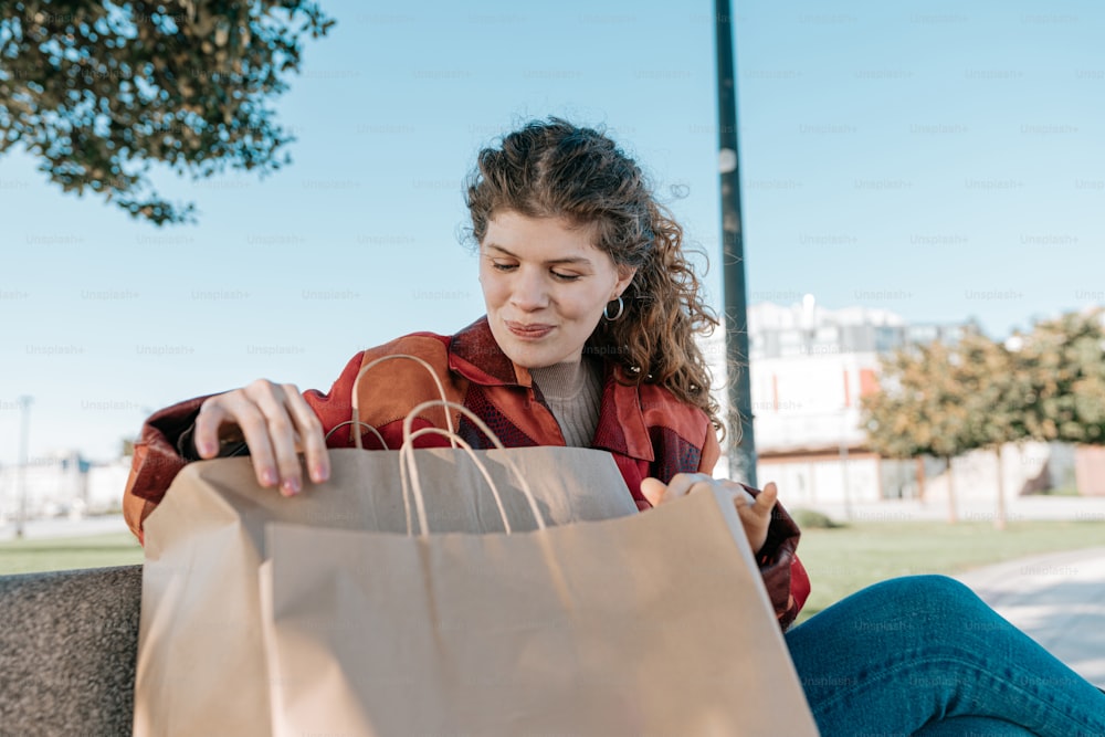 a woman sitting on a bench holding a brown bag