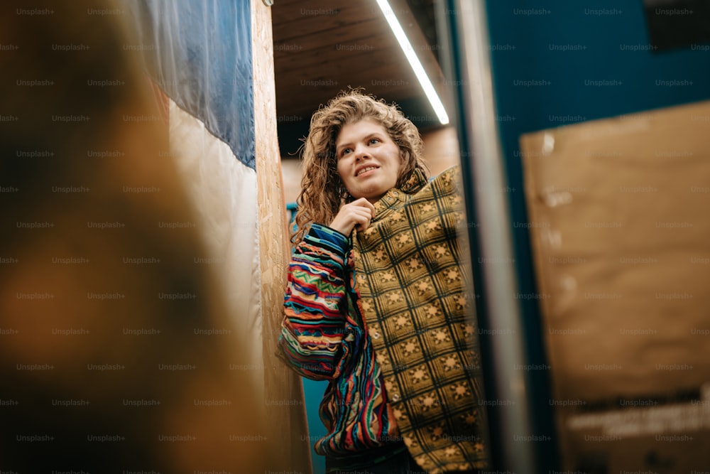 une femme debout devant un miroir dans une pièce