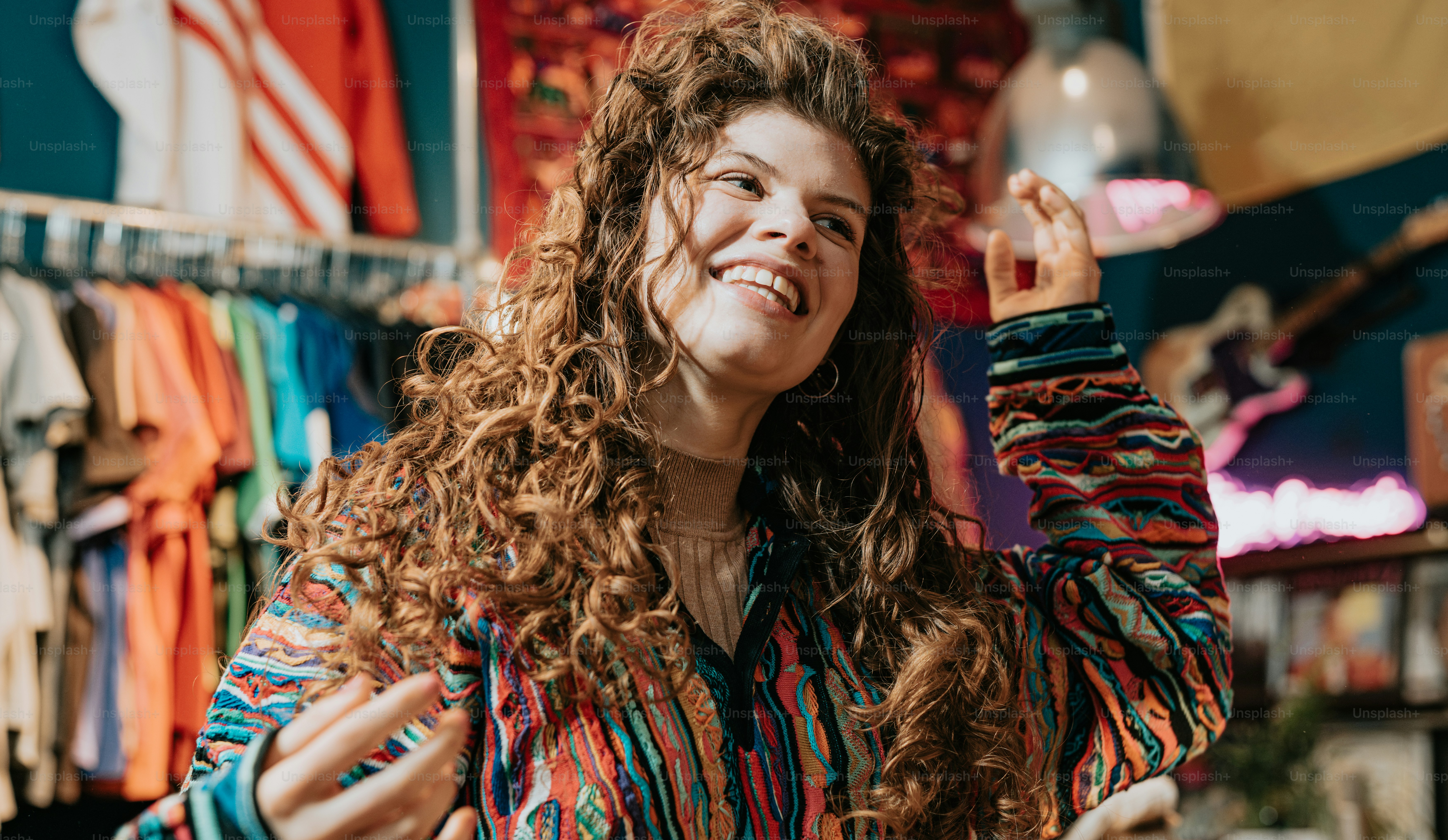 a woman standing in front of a rack of clothing