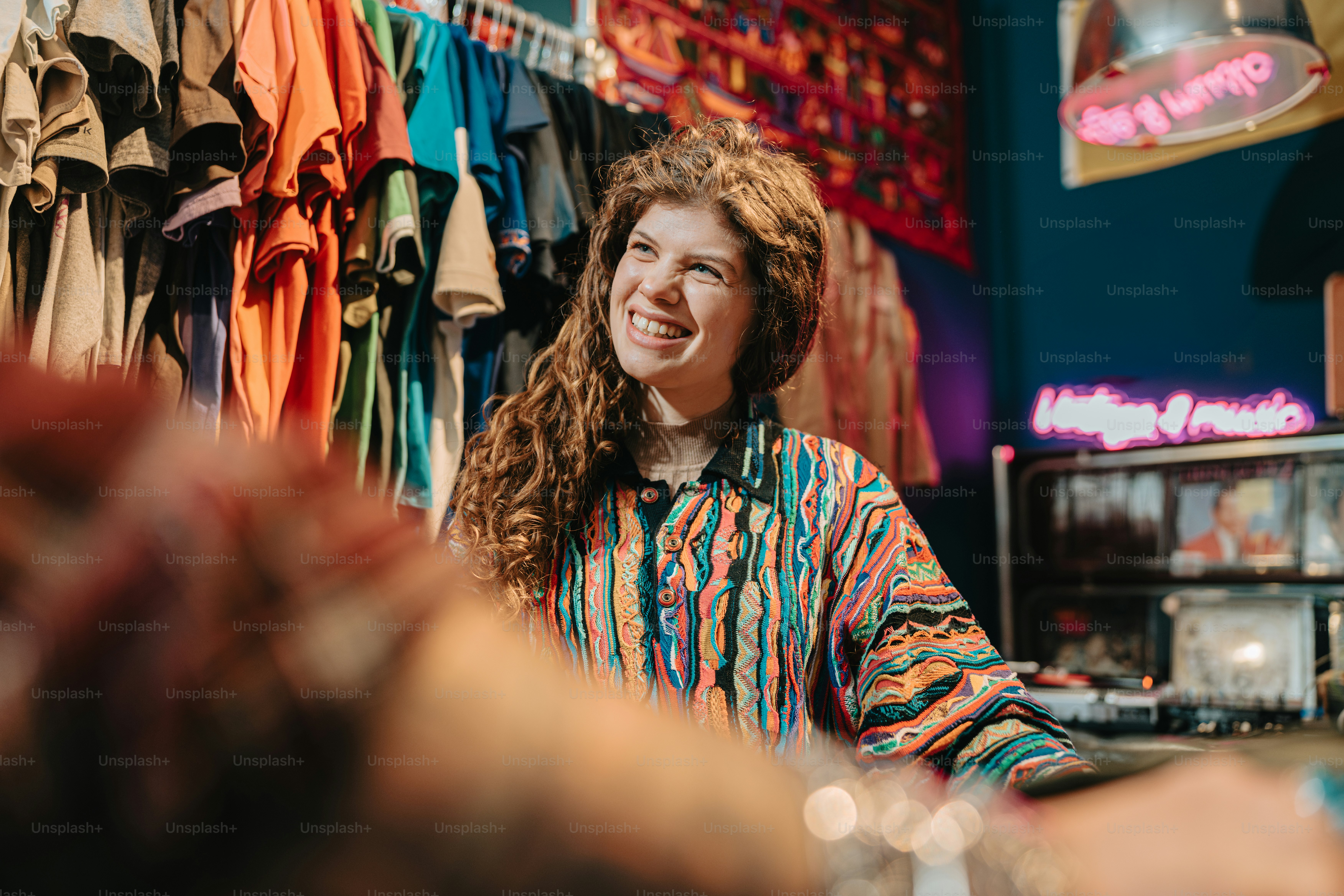 a woman sitting at a counter in a clothing store
