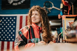 a woman with long hair standing in front of an american flag