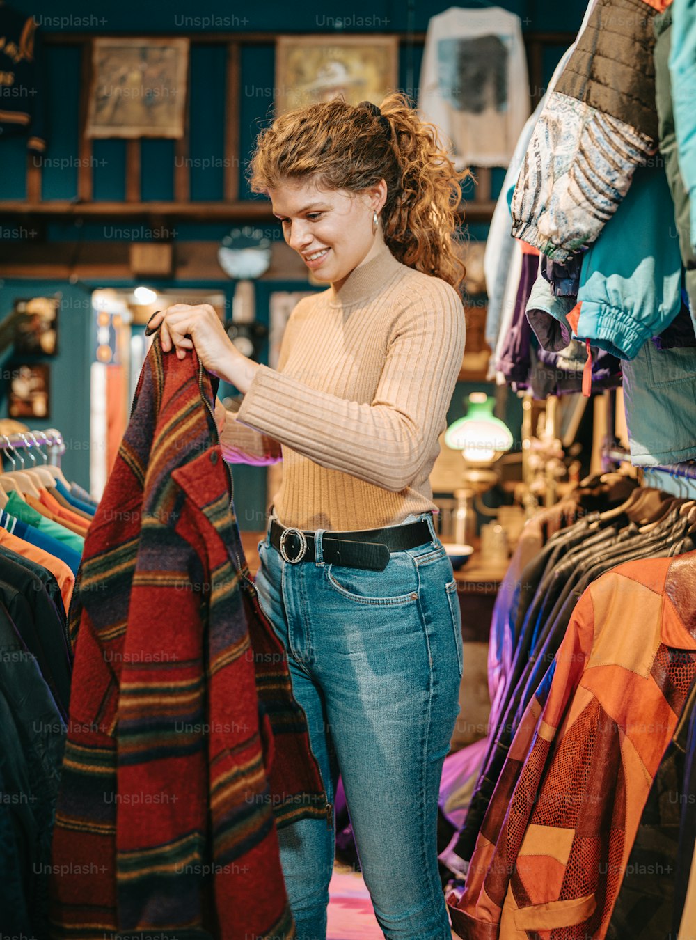 Una mujer está mirando un suéter en una tienda de ropa