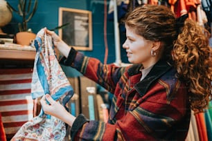 a woman looking at a shirt hanging on a rack