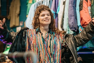 a woman standing in front of a rack of clothes