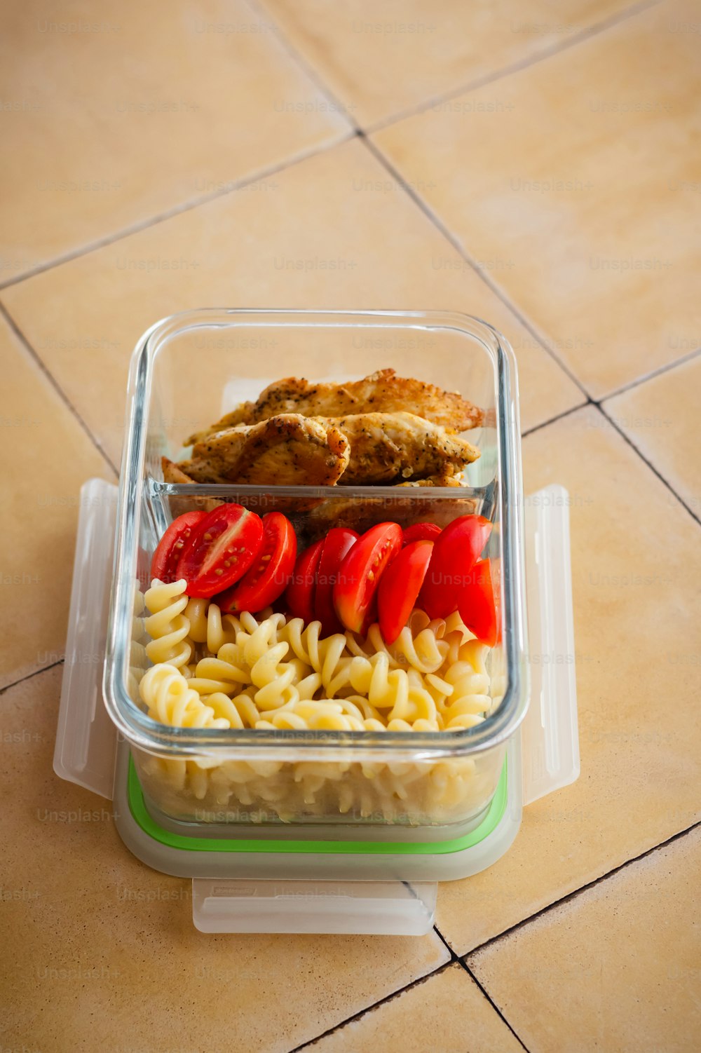 a plastic container filled with pasta and meat