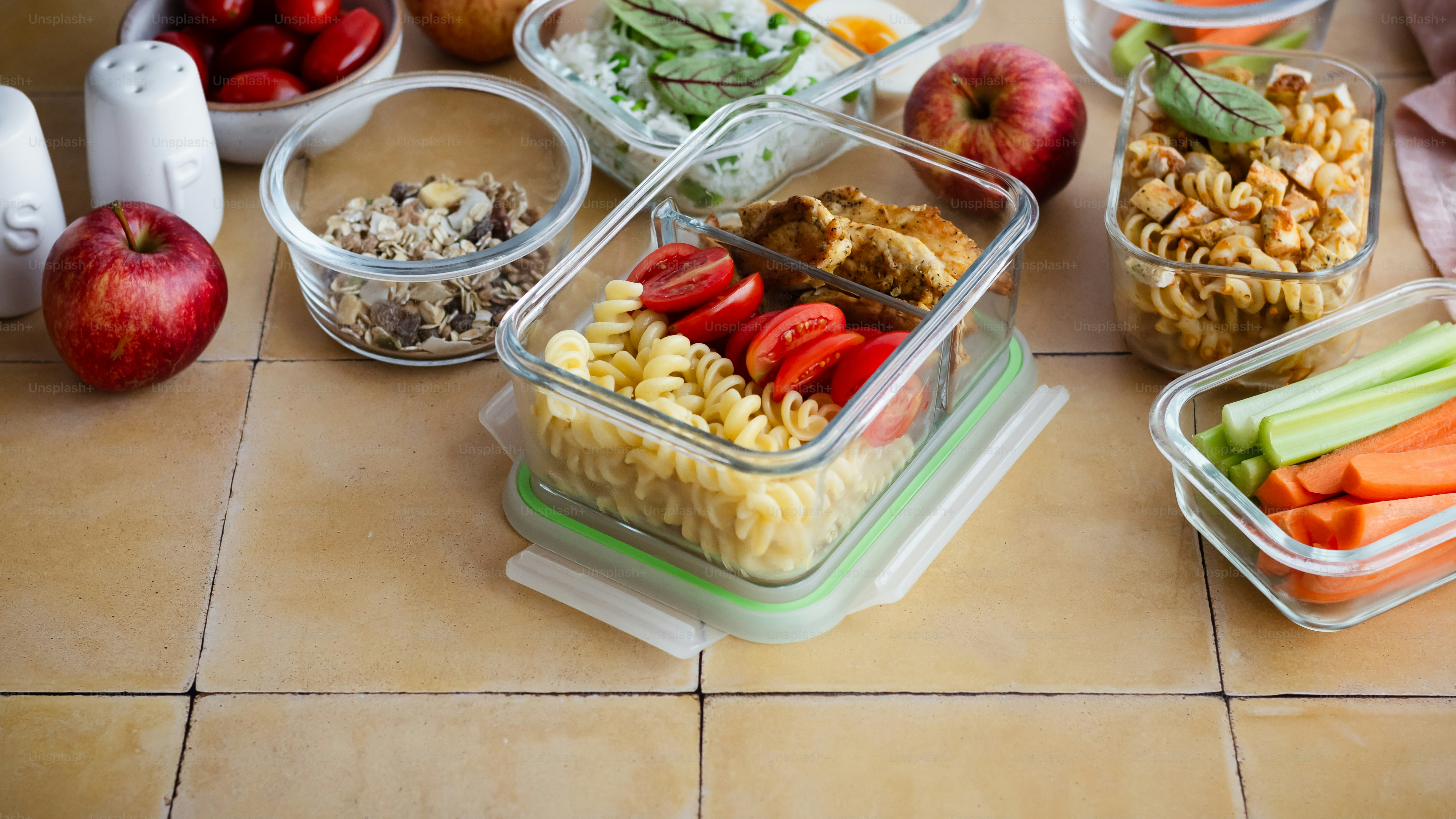 un tavolo sormontato da contenitori di cibo in cima a un pavimento piastrellato