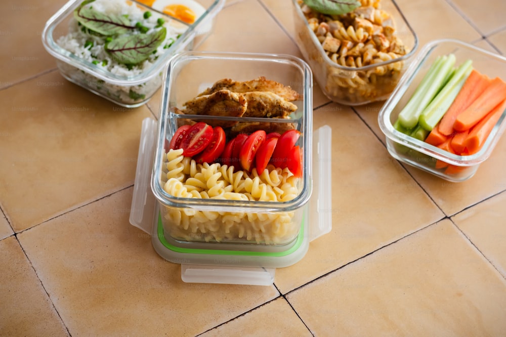 uma variedade de alimentos em recipientes plásticos sobre uma mesa