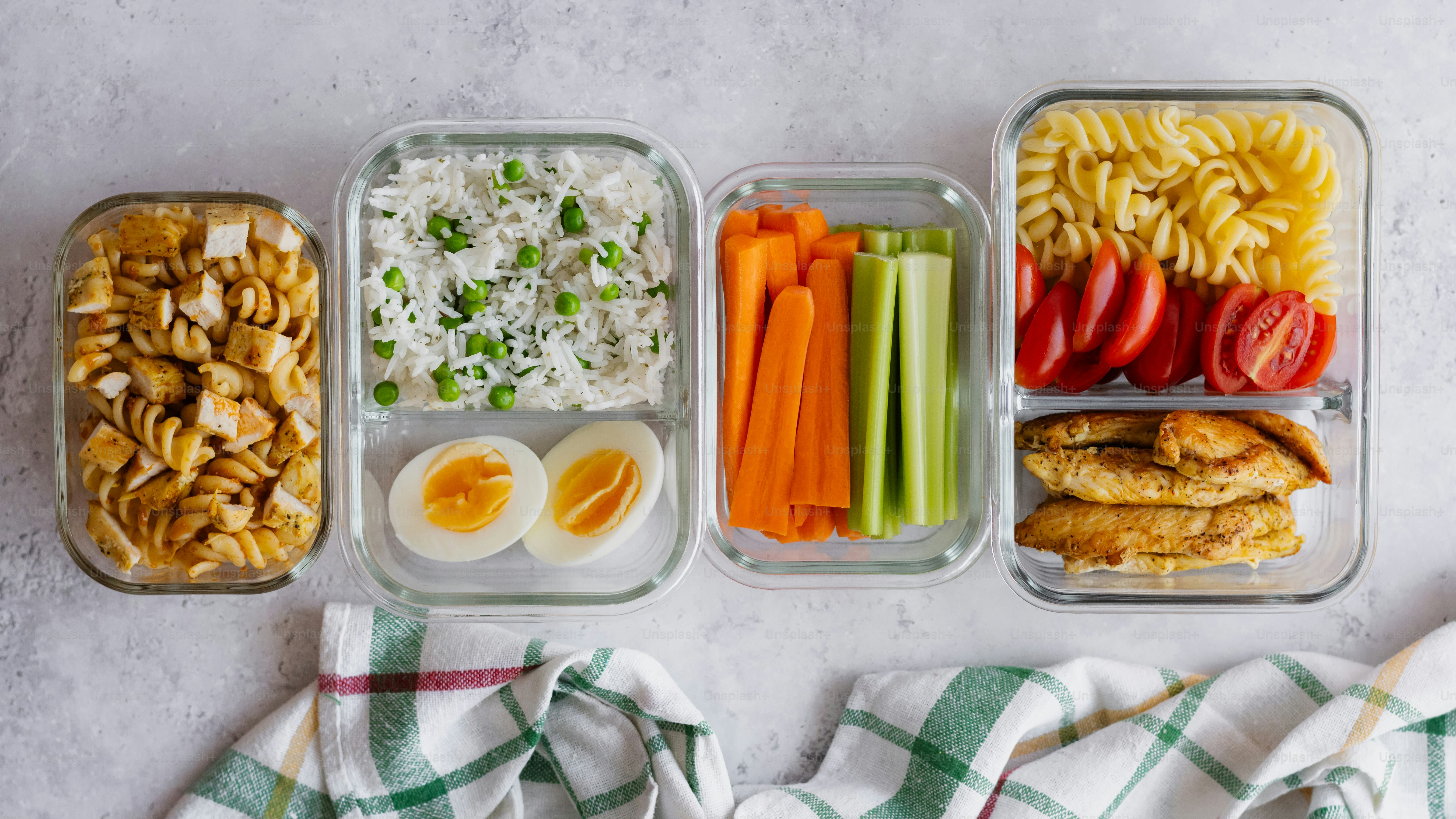 Four containers of food are arranged on a table photo – Healthy food ...