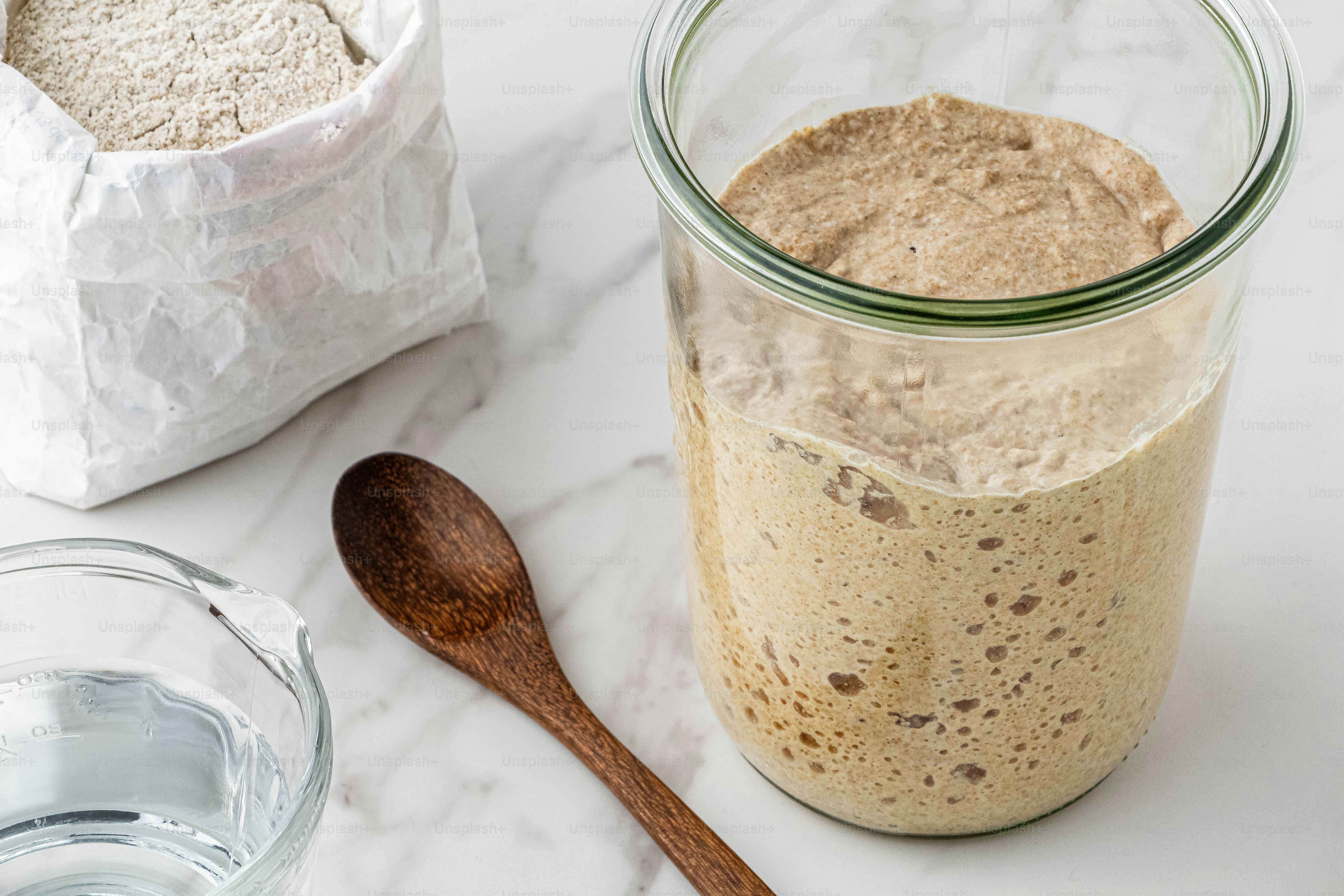 a jar of oatmeal next to a wooden spoon