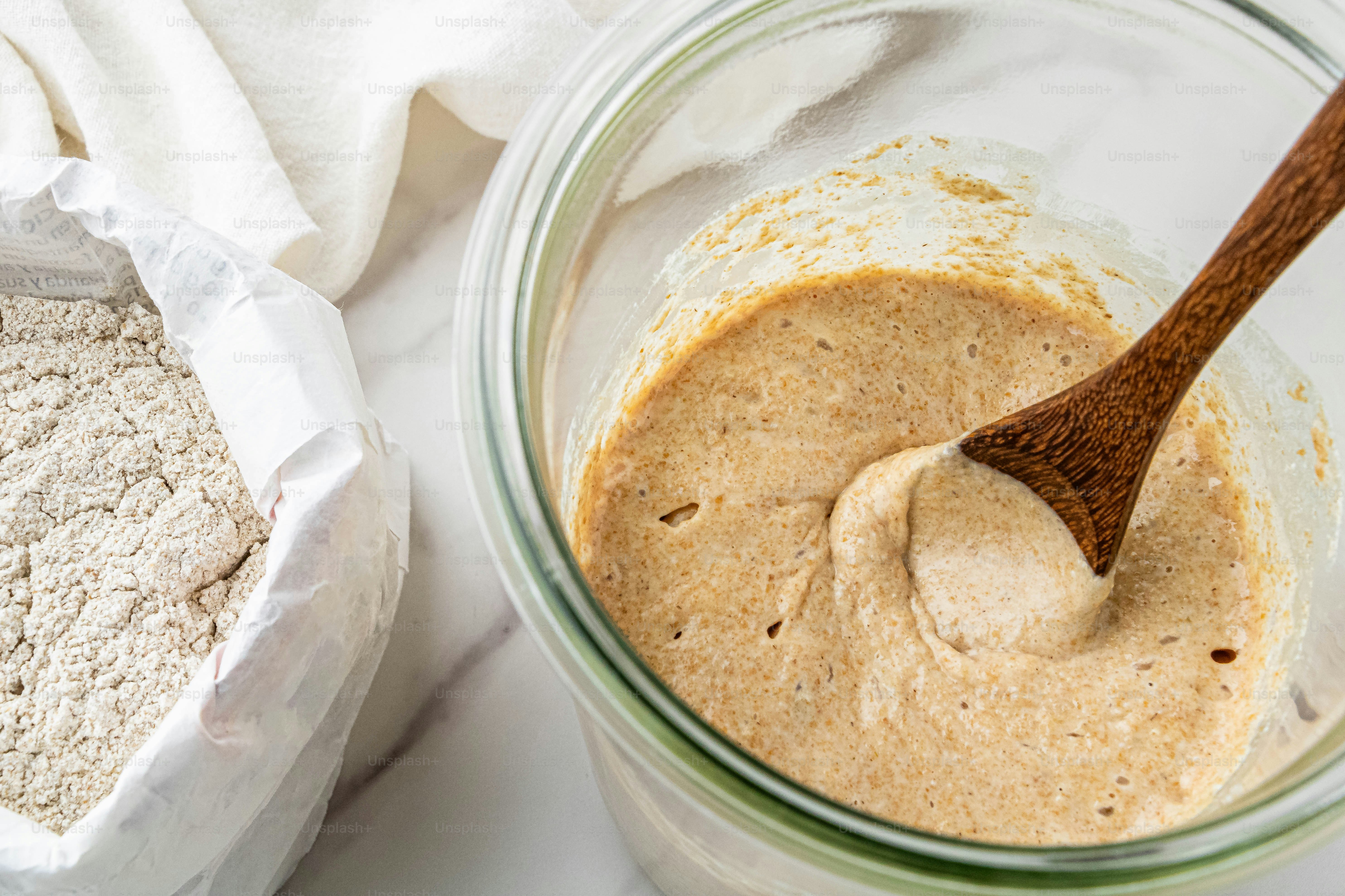 a wooden spoon in a glass bowl of batter