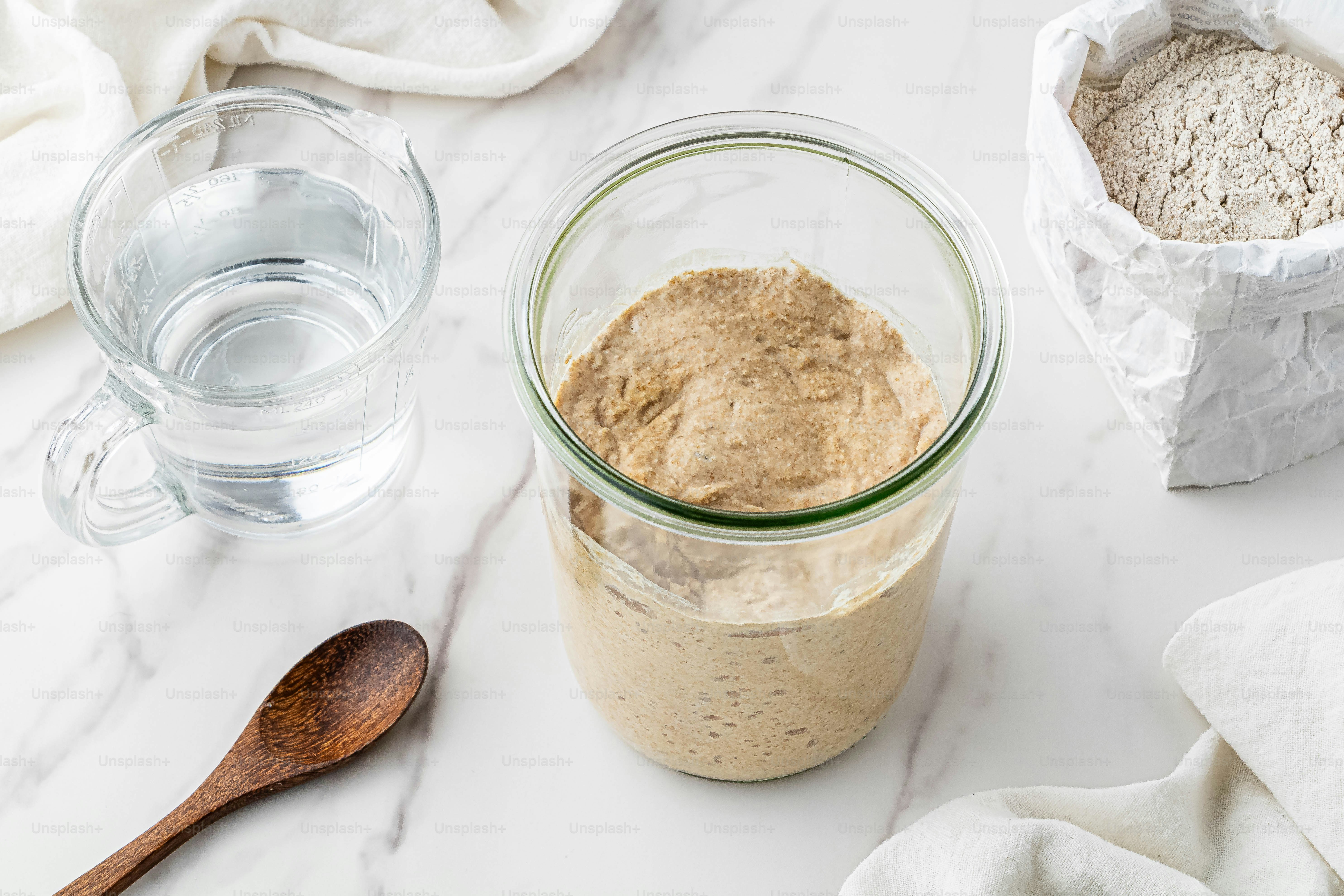 a jar of oatmeal next to a glass of water