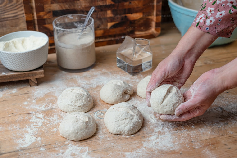 a person is kneading dough balls on a table