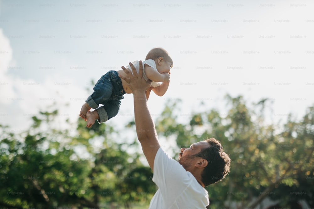 un homme tenant un bébé en l’air
