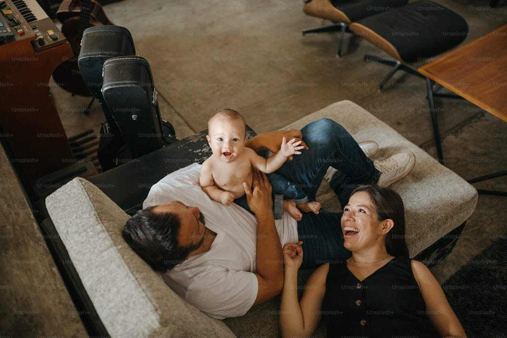 ソファで赤ん坊を抱く女性と男性