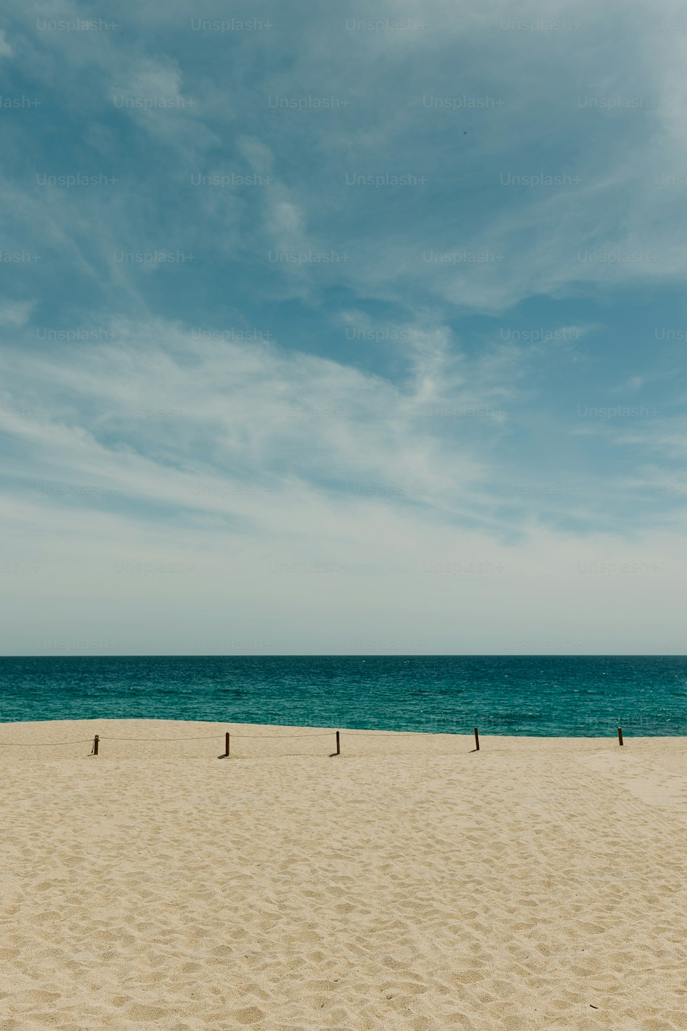 Una spiaggia sabbiosa con un oceano blu sullo sfondo
