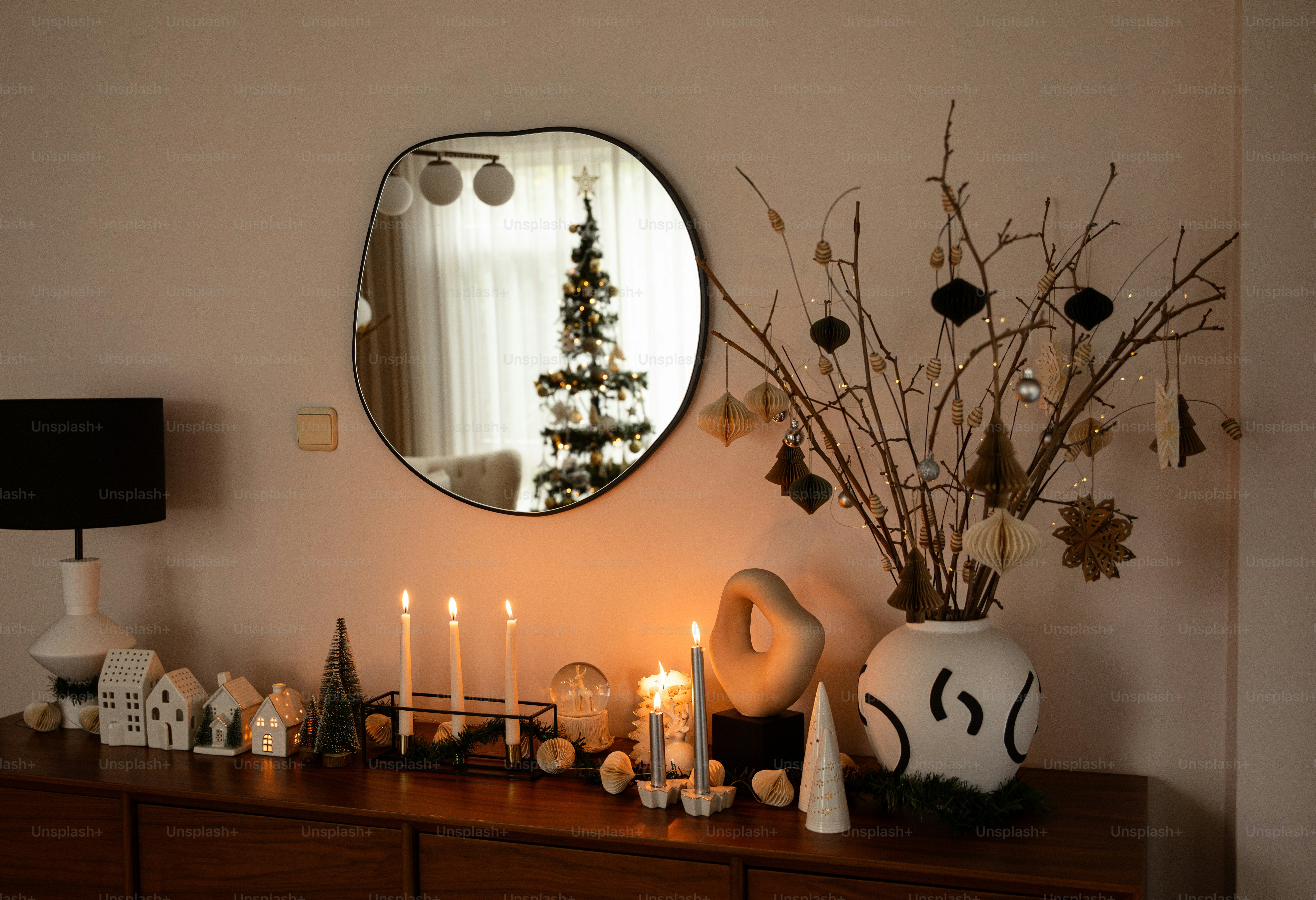 a table topped with a mirror next to a christmas tree