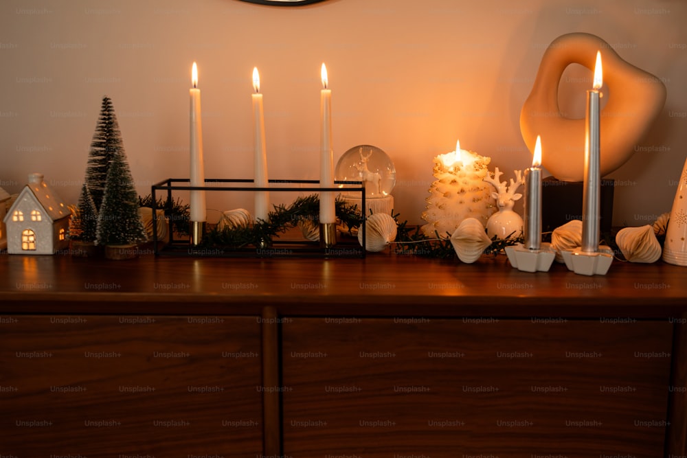 a wooden dresser topped with christmas decorations and candles