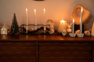 a wooden dresser topped with christmas decorations and candles